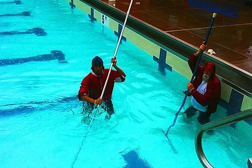 Pool operators cleaning swimming pool